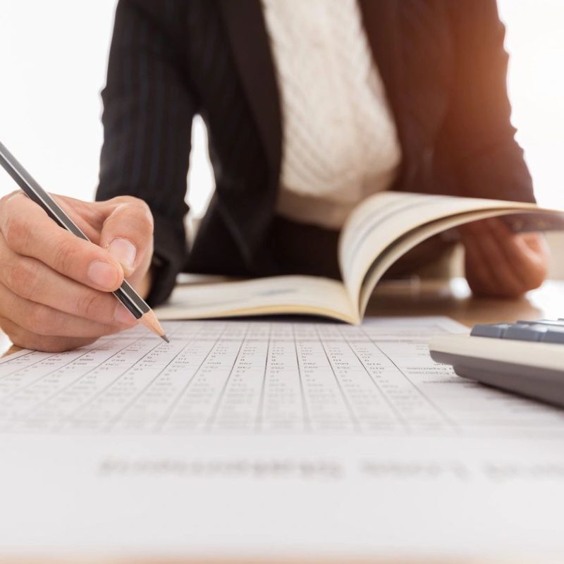 Business person writing on paper